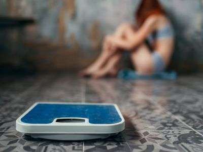 ragazza disperata per il suo peso e bilancia in primo piano