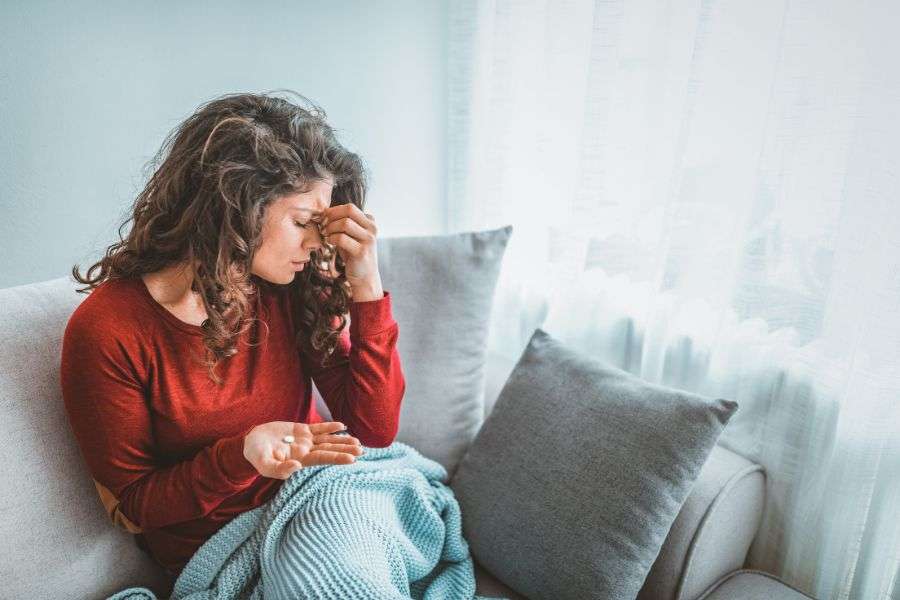 ragazza sul divano per un attacco di emicrania