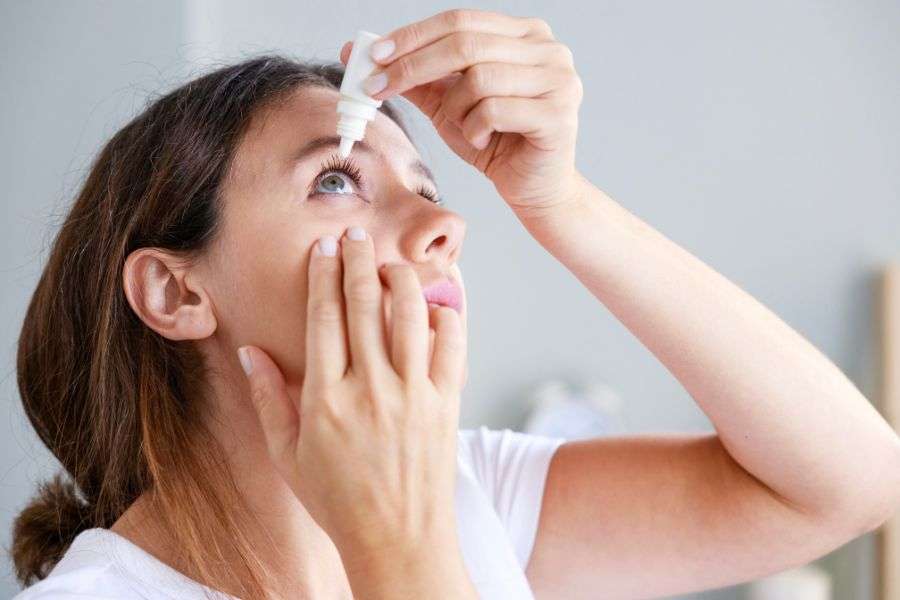 donna che usa il collirio per mantenere il benessere degli occhi