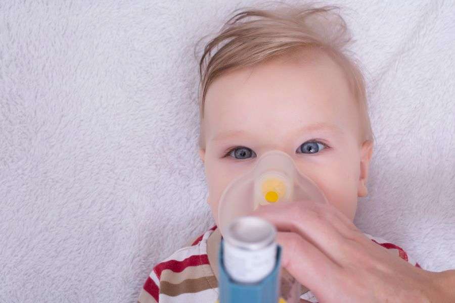 un bambino di circa 9 mesi con mascherina e respiratore