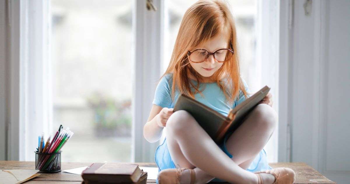 bambina che legge con gli occhiali