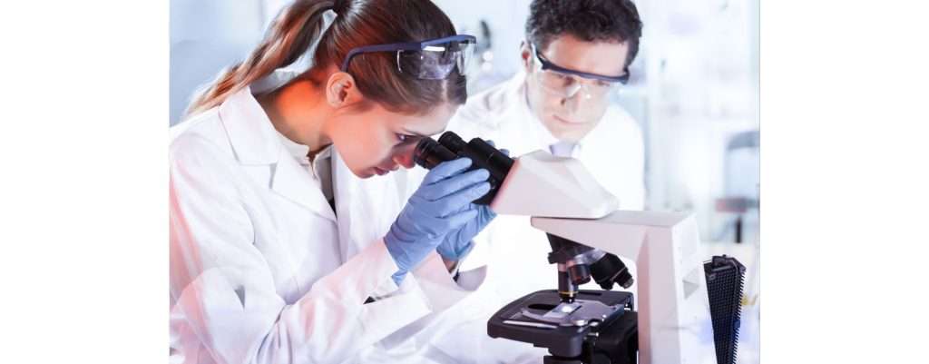 ricercatrice al microscopio, il ruolo della ricerca per intervenire sulle ferite complesse
