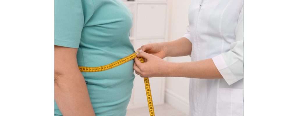 nutrizionista che misura la circonferenza della pancia, misure contro l'obesità