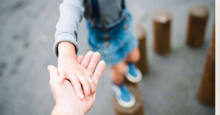 bambino che gioca aiutato da un adulto