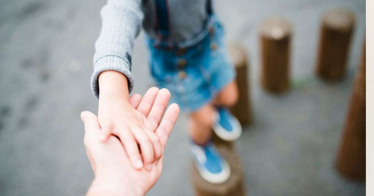bambino che gioca aiutato da un adulto