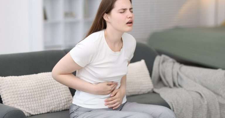 ragazza che accusa dolore allo stomaco