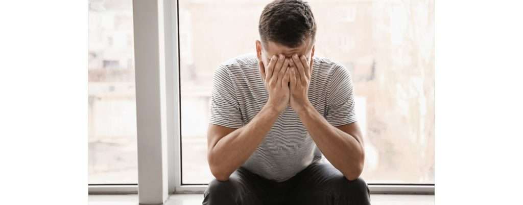 persona con le mani sul volto in segno di disagio