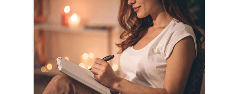 donna che scrive il suo diario a mano in un ambiente rilassato