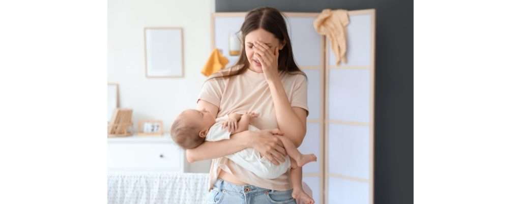 mamma che piange con il figlio in braccio per via della depressione post partum