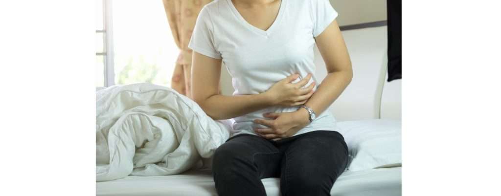 donna che si tiene dolorante il fianco dove c'è il pancreas